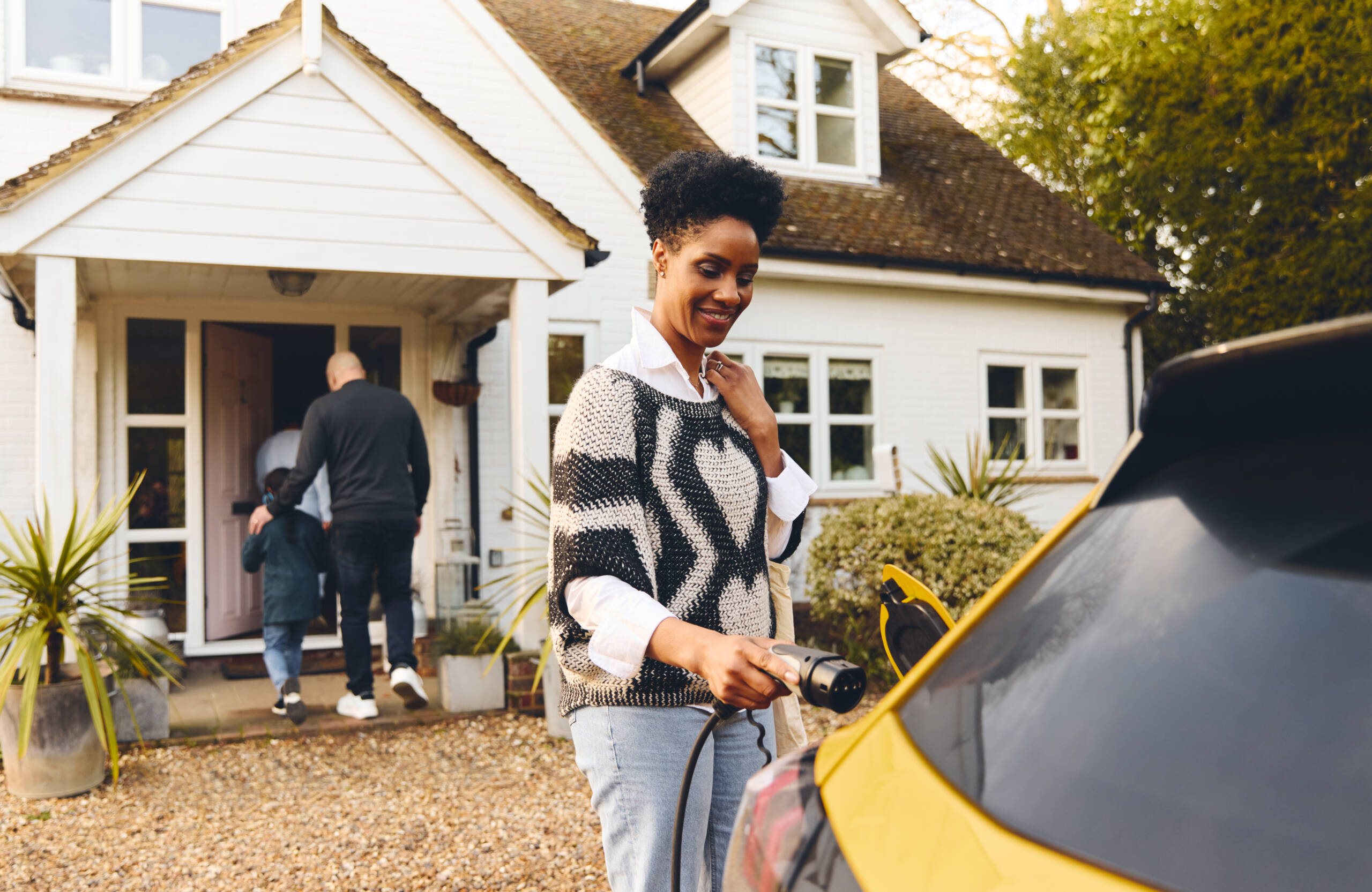 woman using EV charger